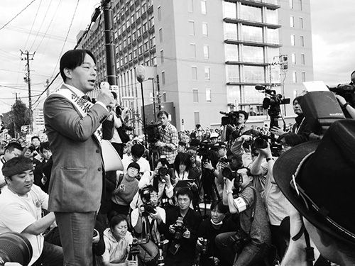 ▶裁判所前で待ち構える原告や支援者に判決内容を報告する筆者、福島地裁前。
